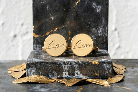 Boutons de manchette ronds en acier doré gravés du mot "Love" par Roaring 20s Paris. Idée cadeau homme.