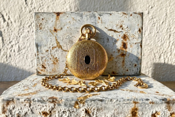 Montre gousset Roaring 20s Paris en acier doré avec mouvement squelette visible et chaîne assortie. Cadeau personnalisé.