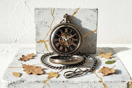 Montre à gousset Roaring 20s Paris en acier laiton, mécanique visible, cadran noir avec chiffres romains, chaîne assortie.