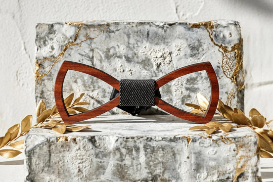 Noeud papillon en bois brun clair ajouré avec bande centrale noire texturée, style bohème chic.