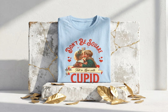 Tee shirt bleu ciel en coton doux, coupe oversize, avec un imprimé vintage recto-verso "Don't Be Square - Fall in Love with Cupid" et "Childhood Love" par Roaring 20s Paris.